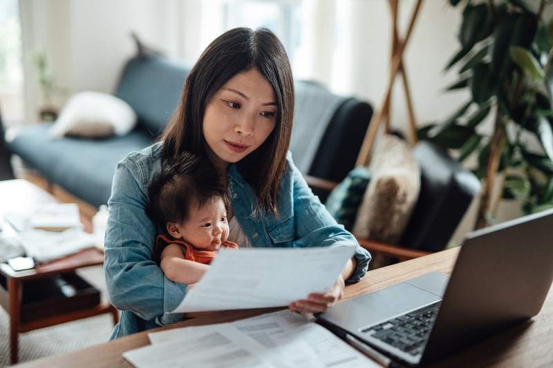 Young mother performing calculations at home to save for a down payment on a house.