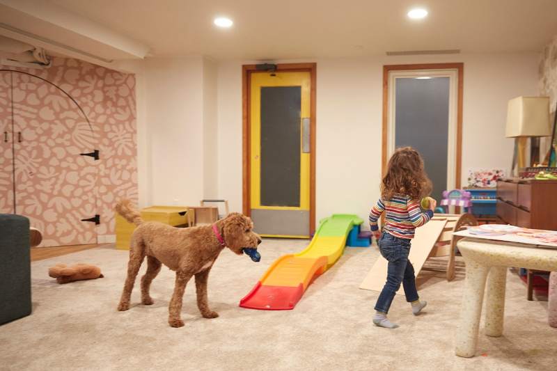 Child plays with dog in a basement that counts toward square footage.