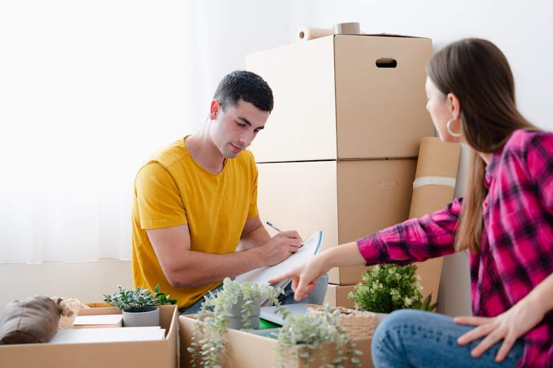 Man and woman document items as they pack them in boxes for a move.