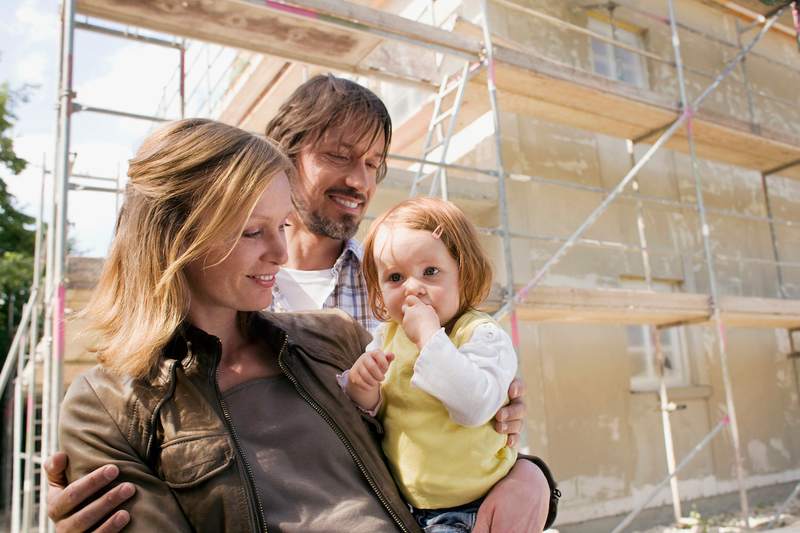 Young family in front of home construction.