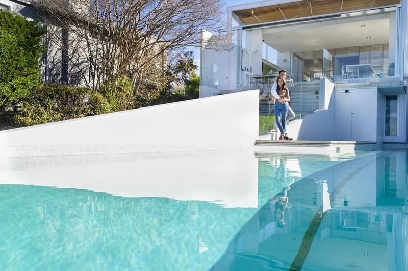 Couple looks at the pool at a modern luxury home.