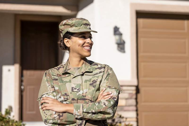 Soldier smiles outside her new home.