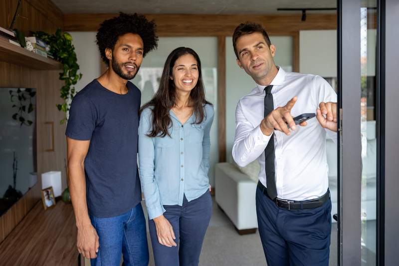 Real estate agent shows a home to a mixed-race couple.