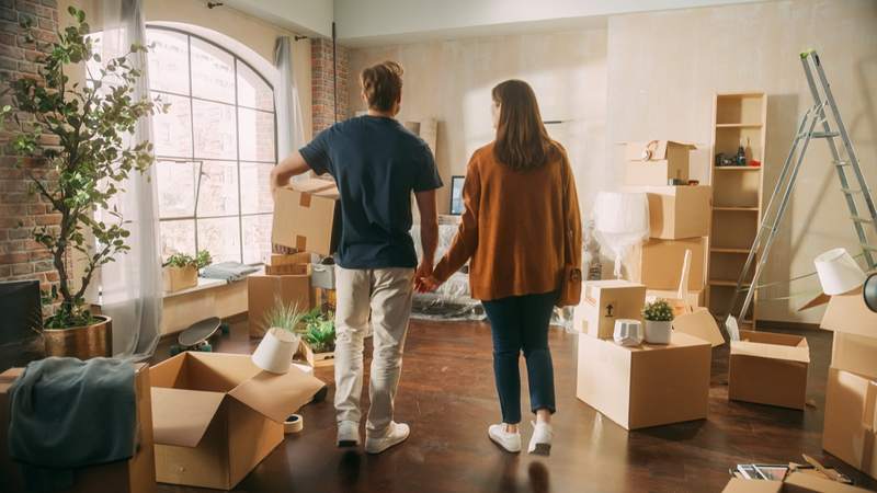 A couple holds hands as they unpack in new home.