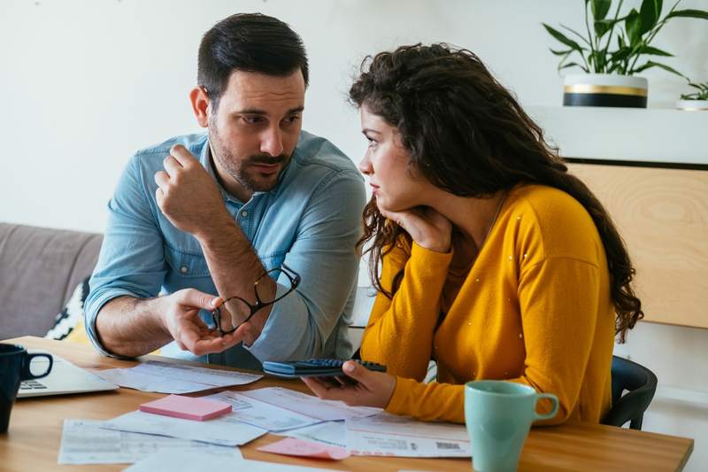 Couple at home discussing and comparing a fixed-rate mortgage vs. an adjustable-rate mortgage (ARM).