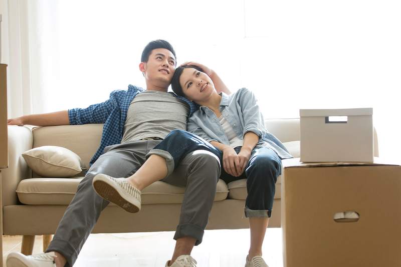 Couple on sofa considers the hidden costs of buying a home.