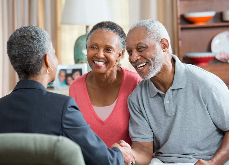 Mortgage advisor meets with older couple.