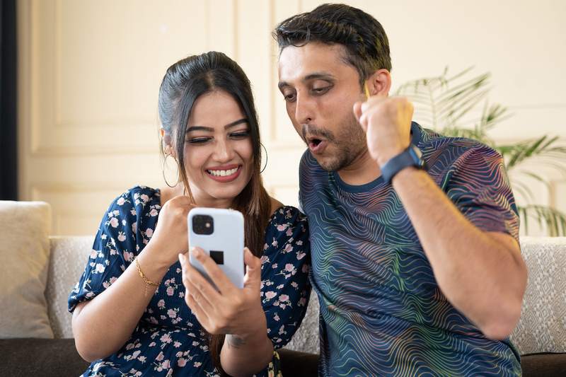 Couple celebrates good news on a house bid received by phone.